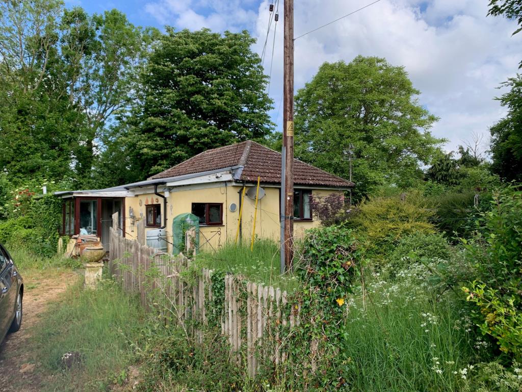 Lot: 121 - FREEHOLD DETACHED BUNGALOW WITH SEPARATE WORKSHOP AND GARAGE ON PLOT OF 0.83 ACRES FOR IMPROVEMENT OR REDEVELOPMENT - Semi-detached bungalow with driveway and gardens